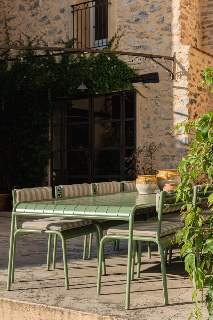 Grande table à manger en métal vert aux lignes arrondies, assises et coussins, bastide Aix-en-Provence